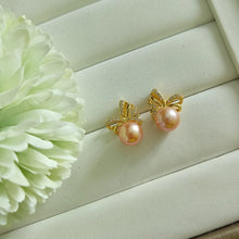 Load image into Gallery viewer, Peachy Pink Freshwater pearls set in CZ delicate ribbon style studs (Gold)